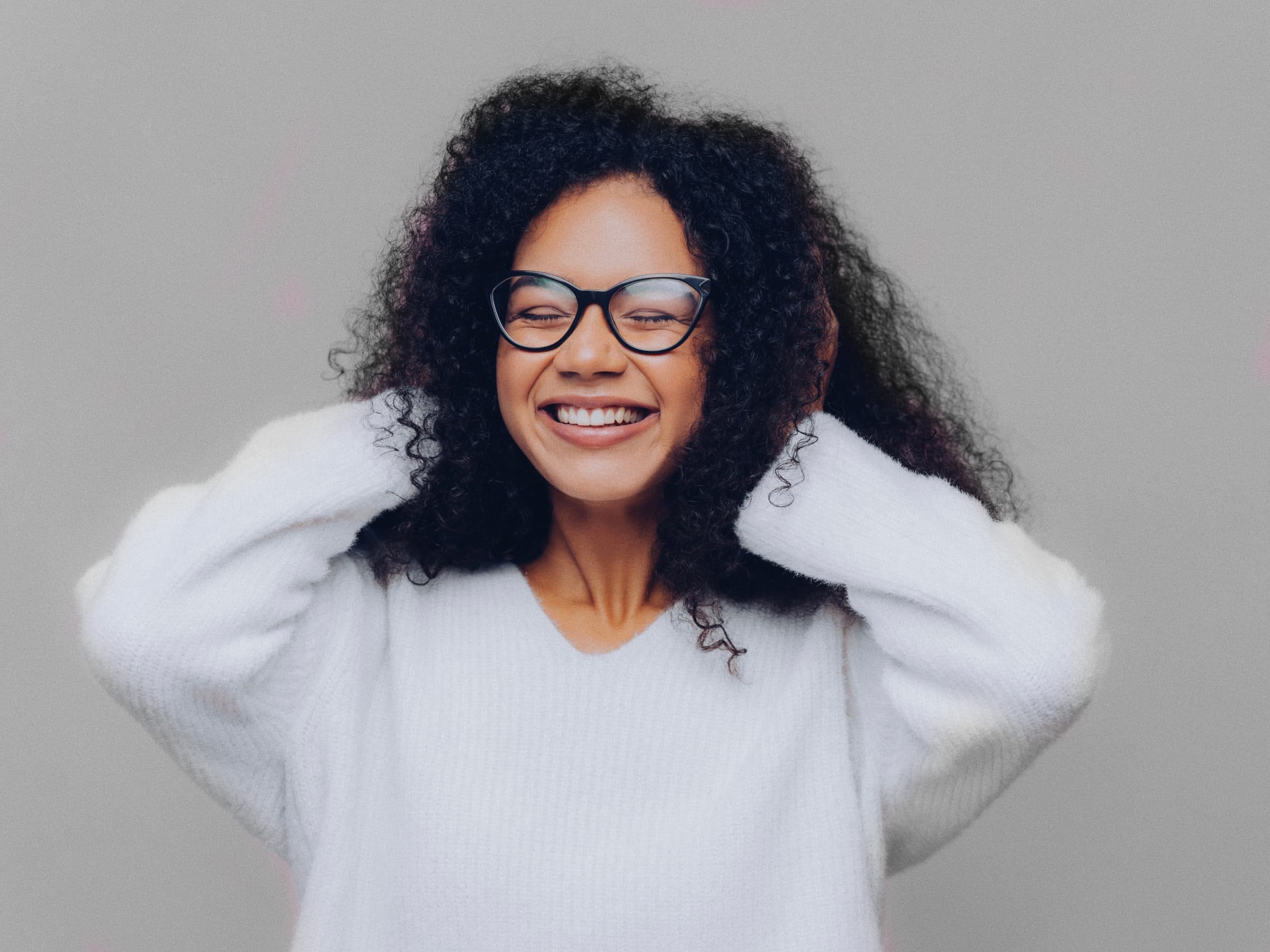 Smiling woman with her hands held over her ears